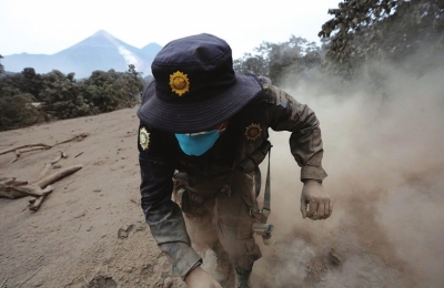 6月4日，在危地马拉埃斯昆特拉，一名救援人员在火山喷发时奔跑躲避。